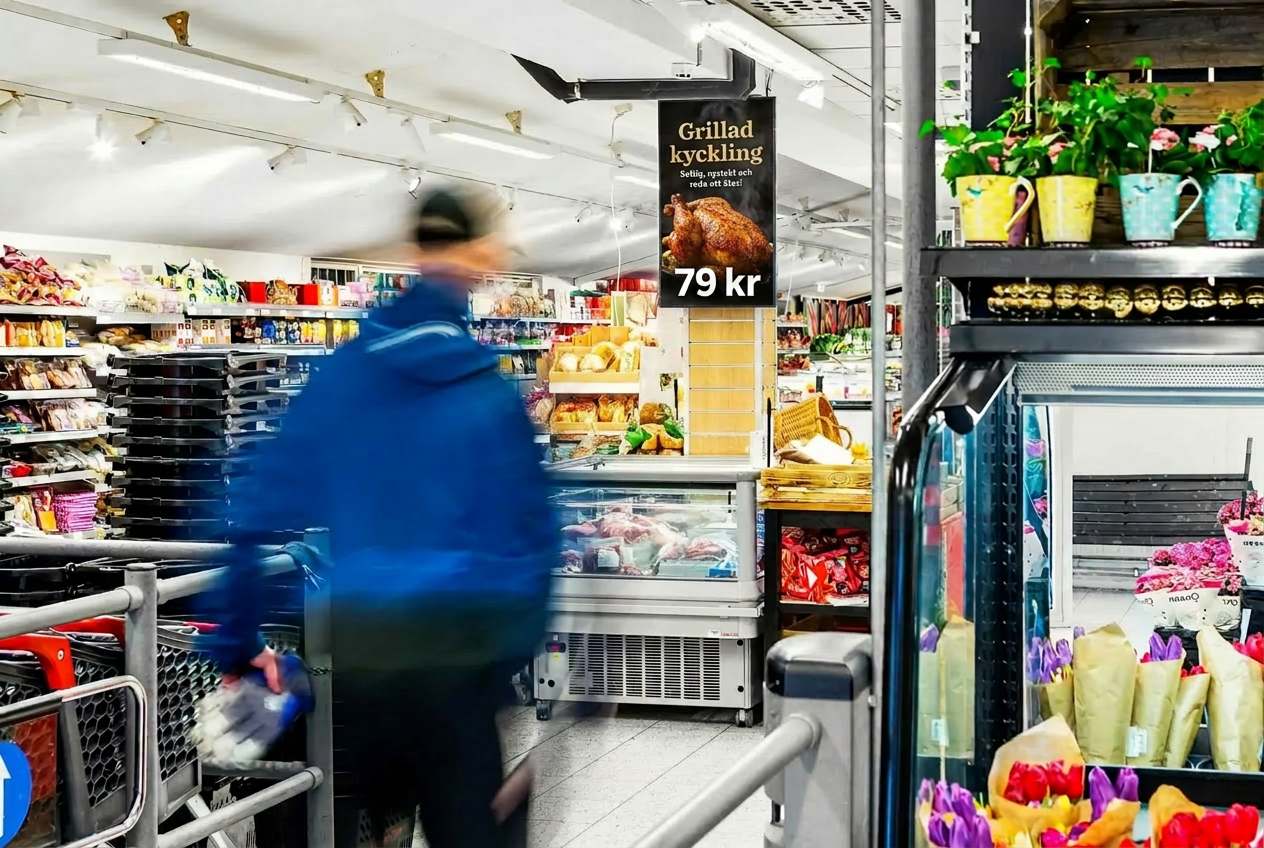 Digital annonsskärm vid entrén i en Hemköp-butik med annons för grillad kyckling